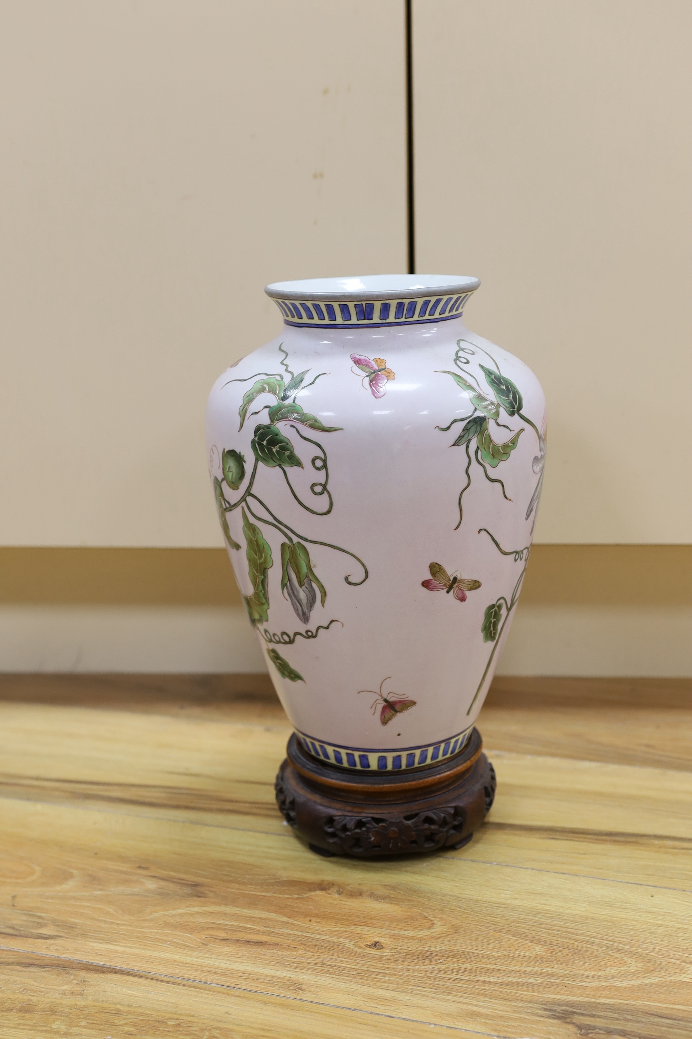 A Chinese famille noire table lamp and a pink ground Chinese vase, both on wooden stands, tallest vase 39cm